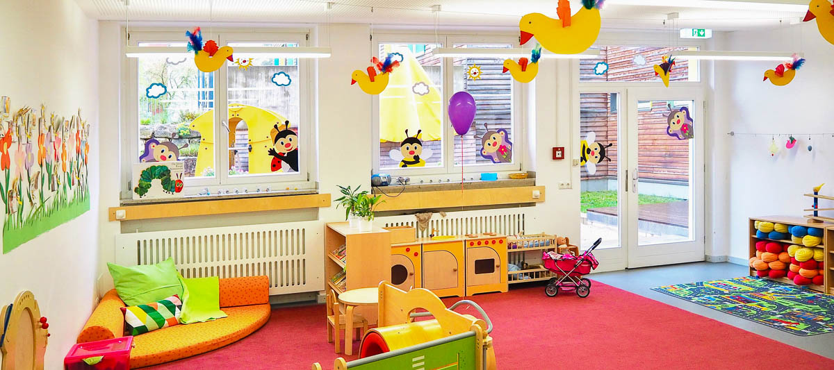 Aufenthalts- und Spielraum der Kinderkrippe Kleine Einsteins in vielen bunten Farben, Spielsachen und Basteleien der Kinder